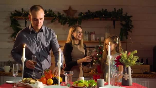 Ευτυχισμένη οικογένεια την Πρωτοχρονιά στο γιορτινό τραπέζι με ποτήρια σαμπάνιας. — Αρχείο Βίντεο