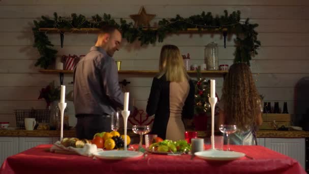 Щаслива і дружня сім'я красиво подає стіл для святкування Нового року — стокове відео