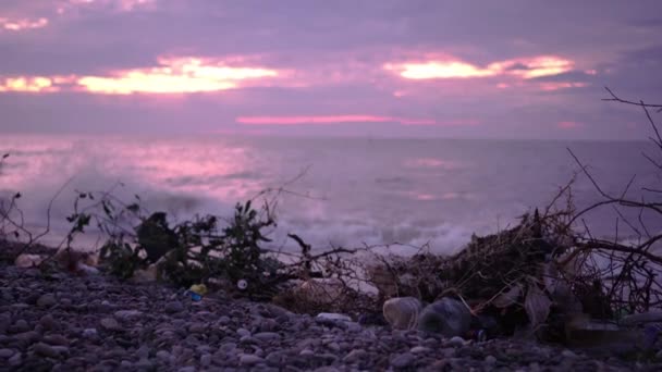 Die Wellen des Meeres brechen bei Sonnenuntergang am felsigen Ufer an — Stockvideo