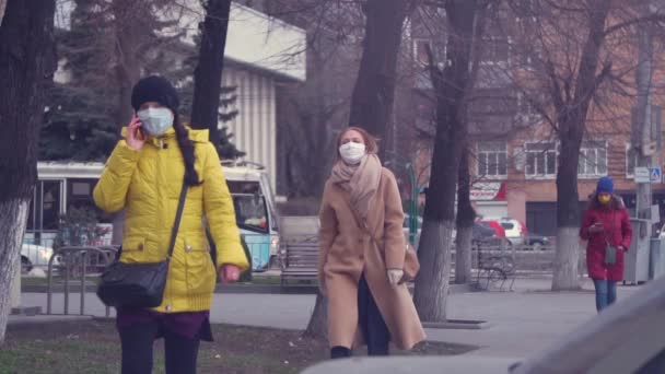 Zamaskowane dziewczyny chodzą ulicą w pochmurną pogodę — Wideo stockowe