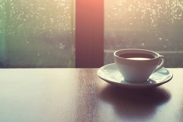 Kahve ürünleri ve bir fincan kahve. Ahşap arka planda, çevre ışığıyla birlikte. Arkaplan için boş alan var.