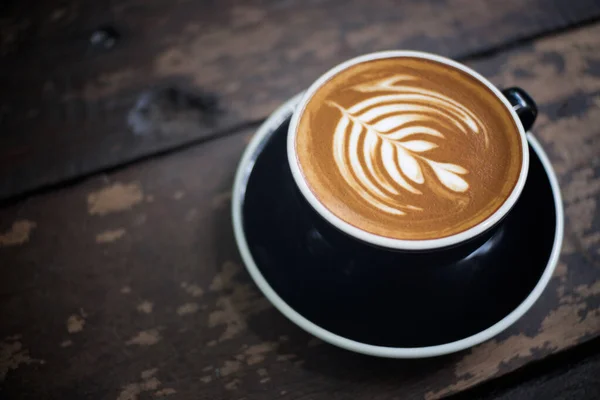 Latte sanat, latte fincanı ahşap bir masada..