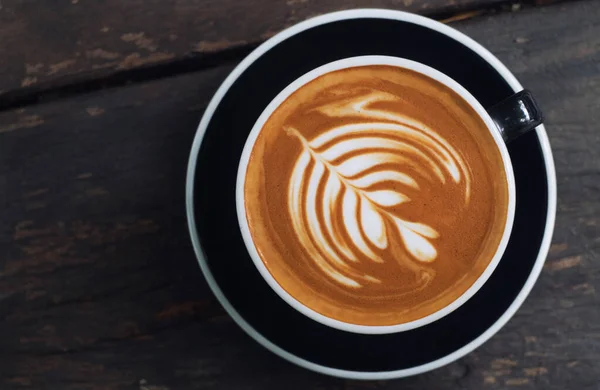 Latte sanat, latte fincanı ahşap bir masada..