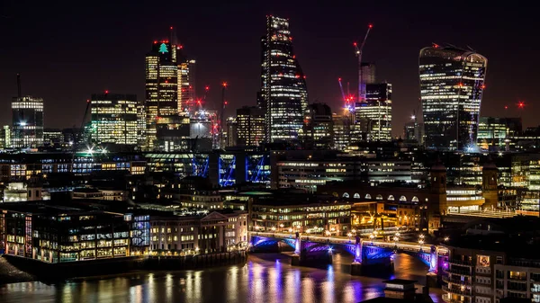 Grandes torres de la ciudad por la noche con luces y reflejos en el río —  Fotos de Stock