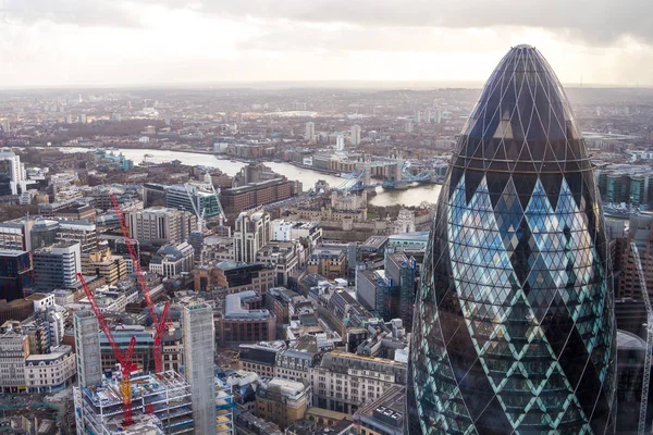 Famosa torre Gherkin de Londres con un Tower Bridge sobre un fondo — Foto de Stock