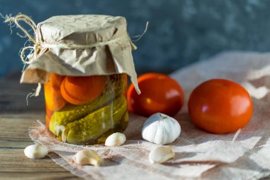 Koyu ahşap arka planda, kaba kumaşlı mayalanmış domatesler..