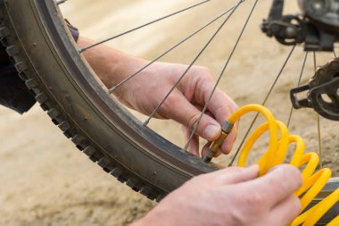 Bir insan sıkıştırılmış havayla bisiklet tekerleğini şişirir. Yumuşak odak.