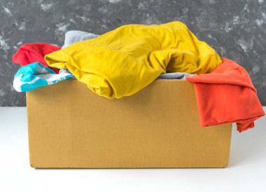 Bağış veya nakliye için karton kutuda giysiler.