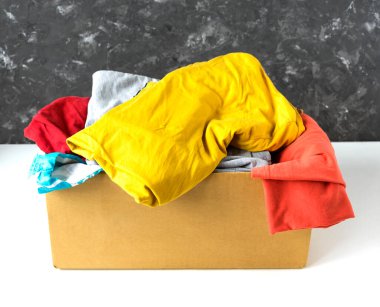 Bağış veya nakliye için karton bir kutuda farklı kıyafetler..