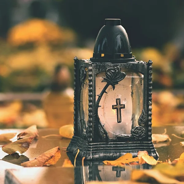 Schönes Herbstkonzept zum Friedhof und zu Halloween. Kerze in einer Laterne auf dem Grab. Hintergrund für Halloween. — Stockfoto