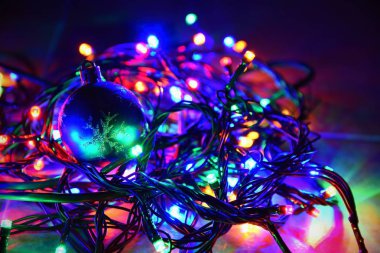 Siyah arka planda fotokopi alanı olan Noel ışıkları. Renkli yansıtıcı yüzey.