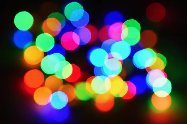 Weihnachtsbeleuchtung auf schwarzem Hintergrund mit Kopierraum. Farbige reflektierende Oberfläche. — Stockfoto