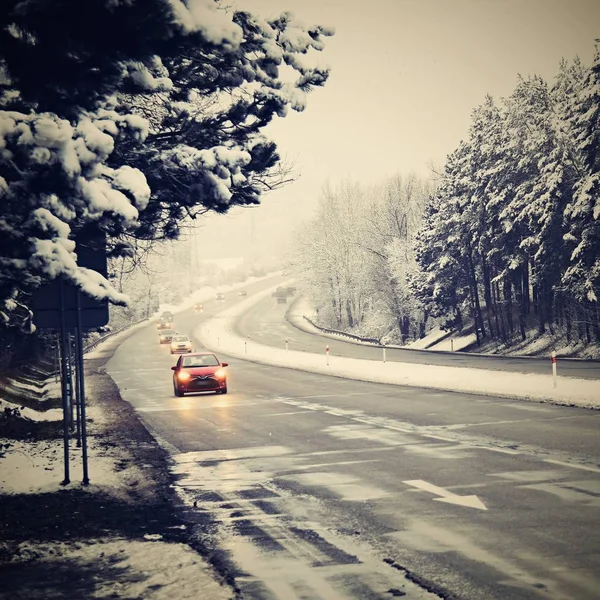 Coches en carretera de invierno con nieve. Tráfico peligroso de automóviles con mal tiempo. — Foto de Stock