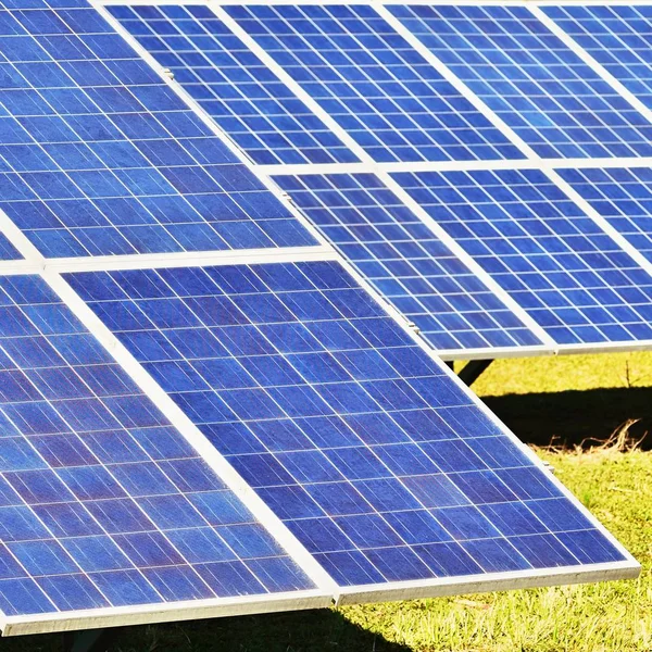 Sun and solar panels in a field. Solar energy power plant. Industrial and ecological concept for nature and eco / green technology. — Stock Photo, Image