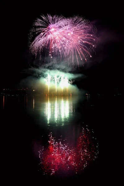 Mooie kleurrijke vuurwerk op het wateroppervlak met een schone zwarte achtergrond. Leuk festival en internationale wedstrijd van de brandweerlieden van over de hele wereld Ignis Brunensis 2017. Brno Dam - Tsjechische R — Stockfoto