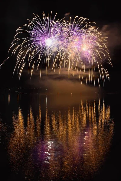 Mooie kleurrijke vuurwerk op het wateroppervlak met een schone zwarte achtergrond. Leuk festival en internationale wedstrijd van de brandweerlieden van over de hele wereld Ignis Brunensis 2017. Brno Dam - Tsjechische R — Stockfoto