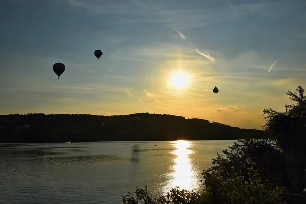 Balão de ar quente colorido está voando ao pôr do sol. Barragem de Brno - República Checa . — Fotografia de Stock