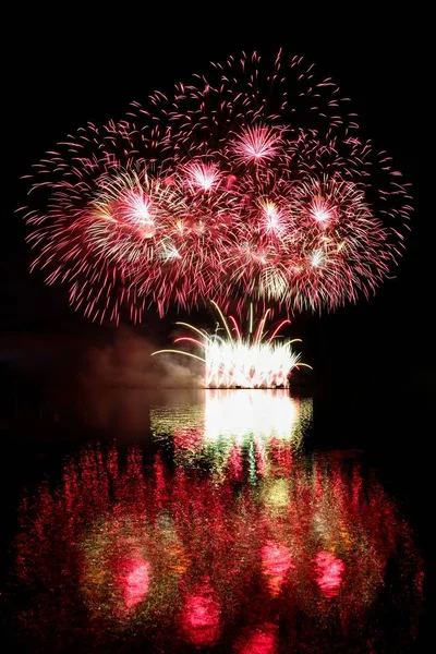 Vuurwerk. Mooie kleurrijke vuurwerk op het wateroppervlak met een schone zwarte achtergrond. Leuk festival en wedstrijd van brandweerlieden Brno Dam - Tsjechië. — Stockfoto