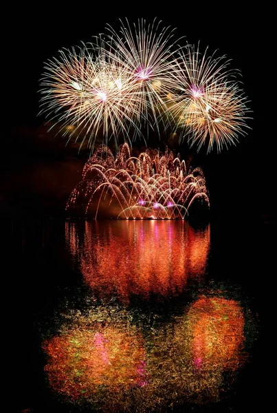 Vuurwerk. Mooie kleurrijke vuurwerk op het wateroppervlak met een schone zwarte achtergrond. Leuk festival en wedstrijd van brandweerlieden Brno Dam - Tsjechië. — Stockfoto