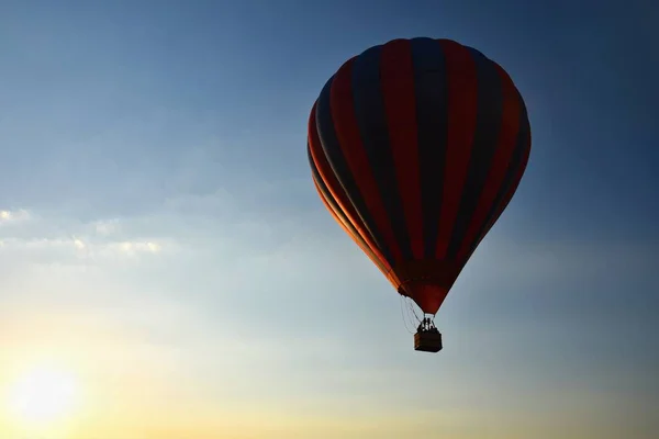 Balão de ar quente colorido está voando ao pôr do sol. Fundo colorido natural com céu . — Fotografia de Stock