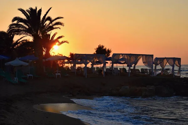 Beautiful summer sunset by the sea. Amazing scenery on the beach with waves and reflection of the sun. Background for holiday and vacation travel. Greece Crete Island. — Stock Photo, Image