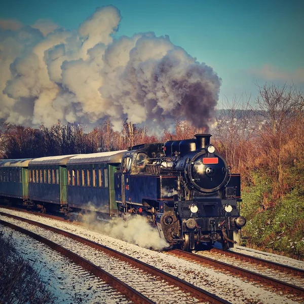 Beautiful old steam train with wagons running on rails at sunset. Excursions for children and parents on festive special days. Czech Republic Europe.