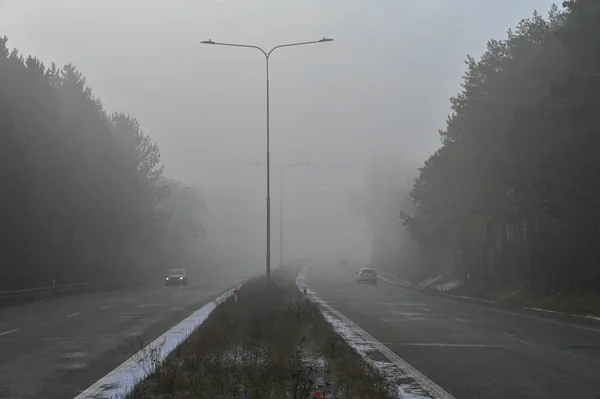 Auta v mlze. Špatného zimního počasí a nebezpečné automobilový provoz na silnici. Lehká vozidla v mlžný den. — Stock fotografie