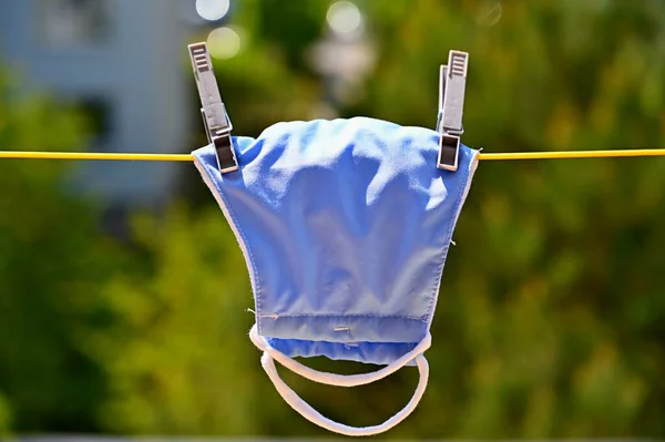 Face mask- respirator on a clothesline. Washing and disinfection against coronavirus COVID - 19.