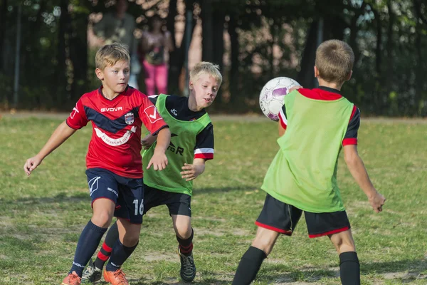 Chicos jugar al fútbol en el campo de deportes —  Fotos de Stock