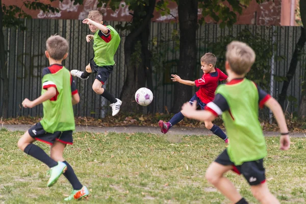 Chicos jugar al fútbol en el campo de deportes —  Fotos de Stock