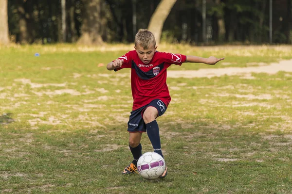 Junge schlägt beim Fußballspiel auf den Ball ein — Stockfoto