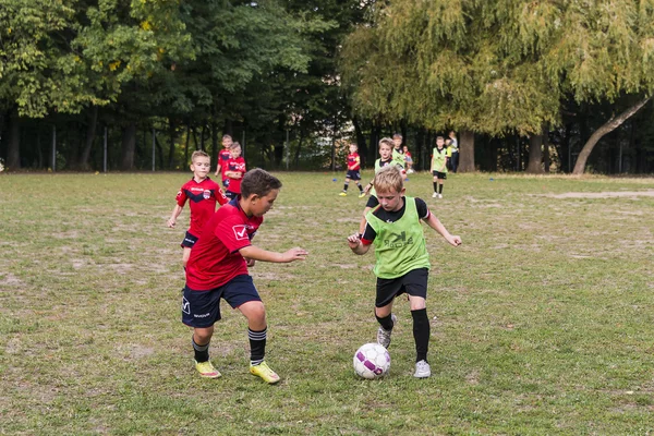 Chicos jugar al fútbol en el campo de deportes —  Fotos de Stock