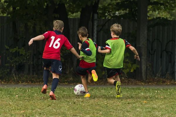 Chicos jugar al fútbol en el campo de deportes — Foto de Stock