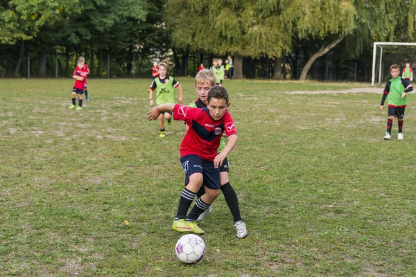 Chlapci hrají fotbal na sportovním poli — Stock fotografie