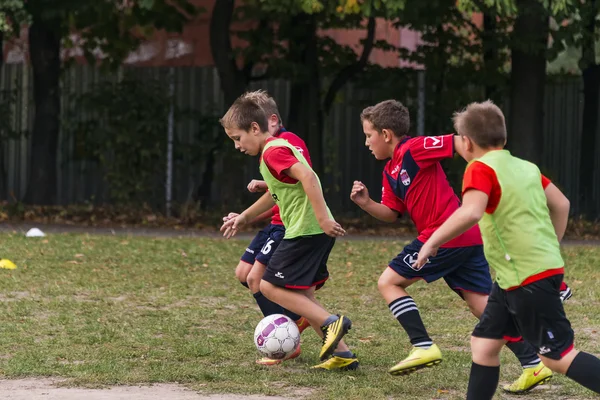 Chicos jugar al fútbol en el campo de deportes —  Fotos de Stock