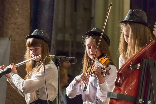 Девушки играют на скрипке и флейте во время концерта — стоковое фото