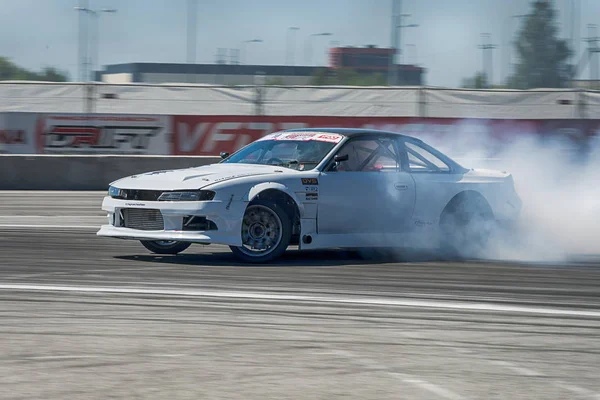 Unknown rider on the car brand Nissan overcomes the track — Stock Photo, Image