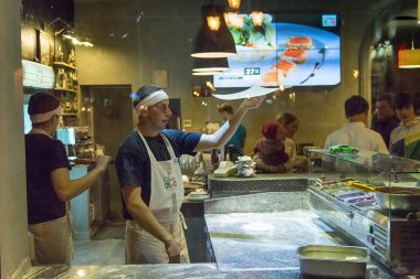 Pizzaillo şehir merkezinde bir pizzacı pizza hazırlar 