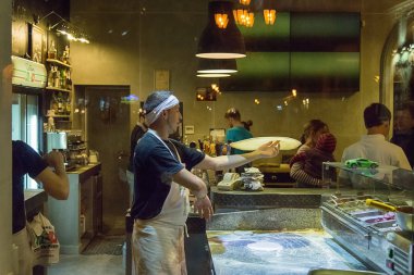 Pizzaillo içinde bir pizzacı pizza ziyaretçiler için hazırlar..