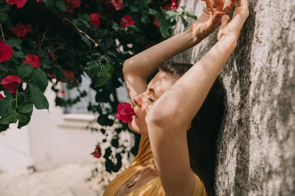 彼女の口の中にピンクのブーゲンビリアの花を持つ少女の肖像画地中海の夏 — ストック写真