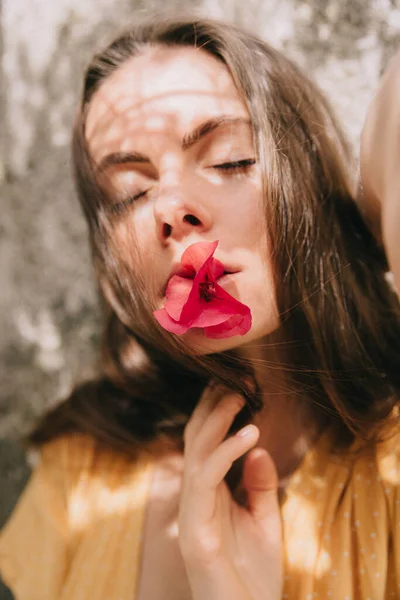 Retrato de una niña con una flor de buganvilla rosa en la boca, en el verano en el Mediterráneo —  Fotos de Stock