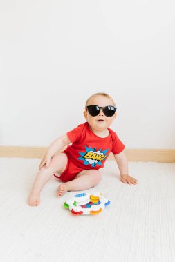Beyaz arka planda güneş gözlüklü tatlı mutlu bebek, yaz tatili konsepti.