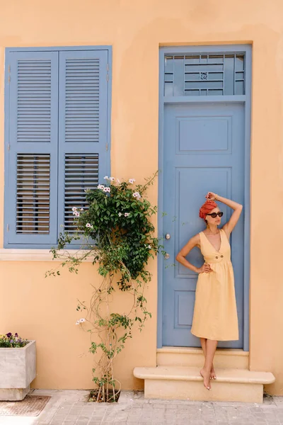 Jolie jeune touriste féminine posant devant une belle porte dans le centre de la vieille ville méditerranéenne, sa coiffure rehaussée de turban — Photo