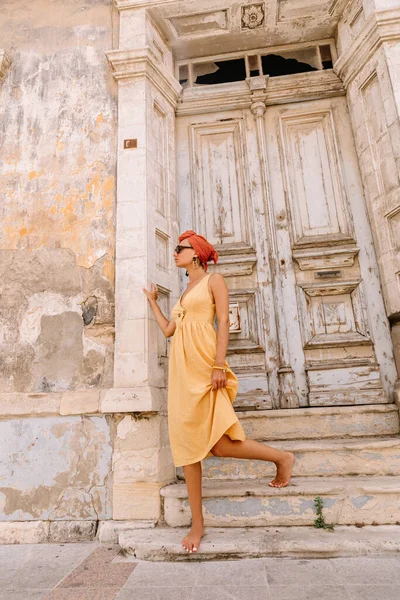 Akdeniz 'in merkezinde güzel bir kapının önünde poz veren güzel bir bayan turist. Saç stili türbanla geliştirilmiş.
