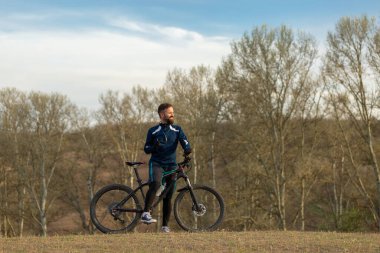 Bisikletçi ormanda geziyor.