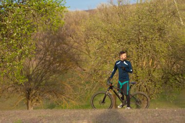Bisikletçi ormanda geziyor.