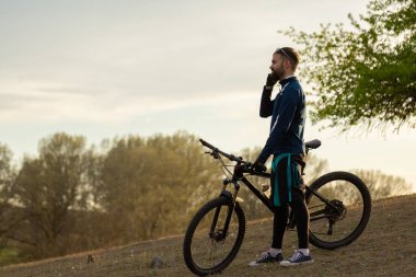 Bisikletçi ormanda geziyor.