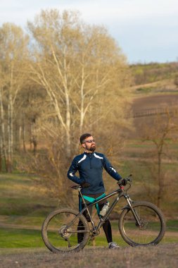 Bisikletçi ormanda geziyor.