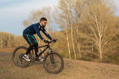 Bisikletçi ormanda geziyor.