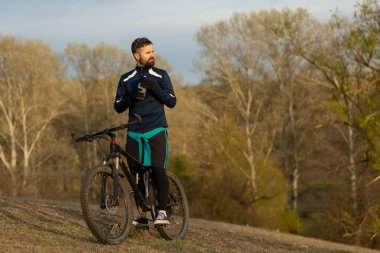 Bisikletçi ormanda geziyor.